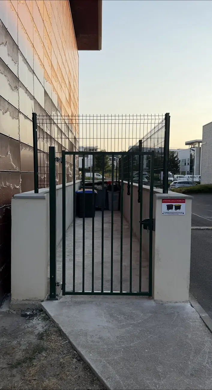 Local poubelles sécurisé par clôture et portillon